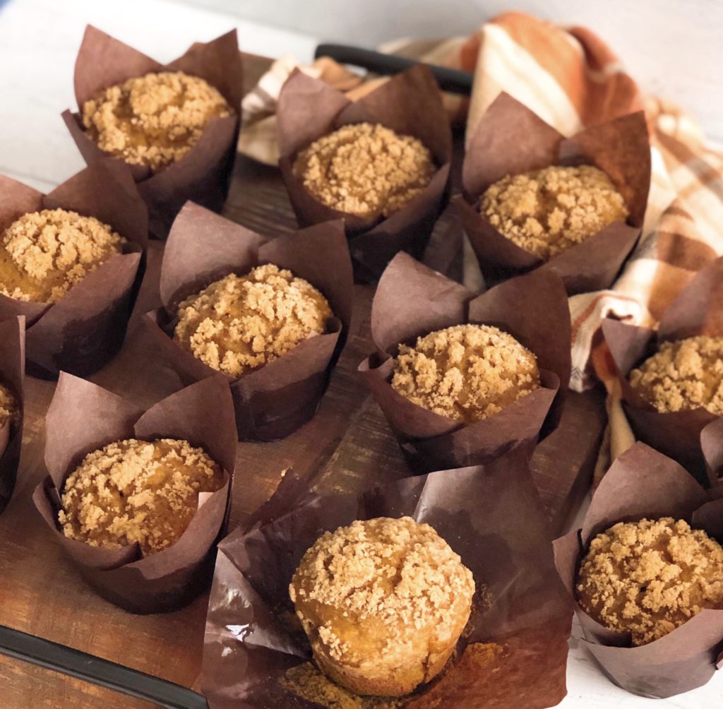 Pumpkin Streusel Muffins on brown paper muffin liners on a wooden board