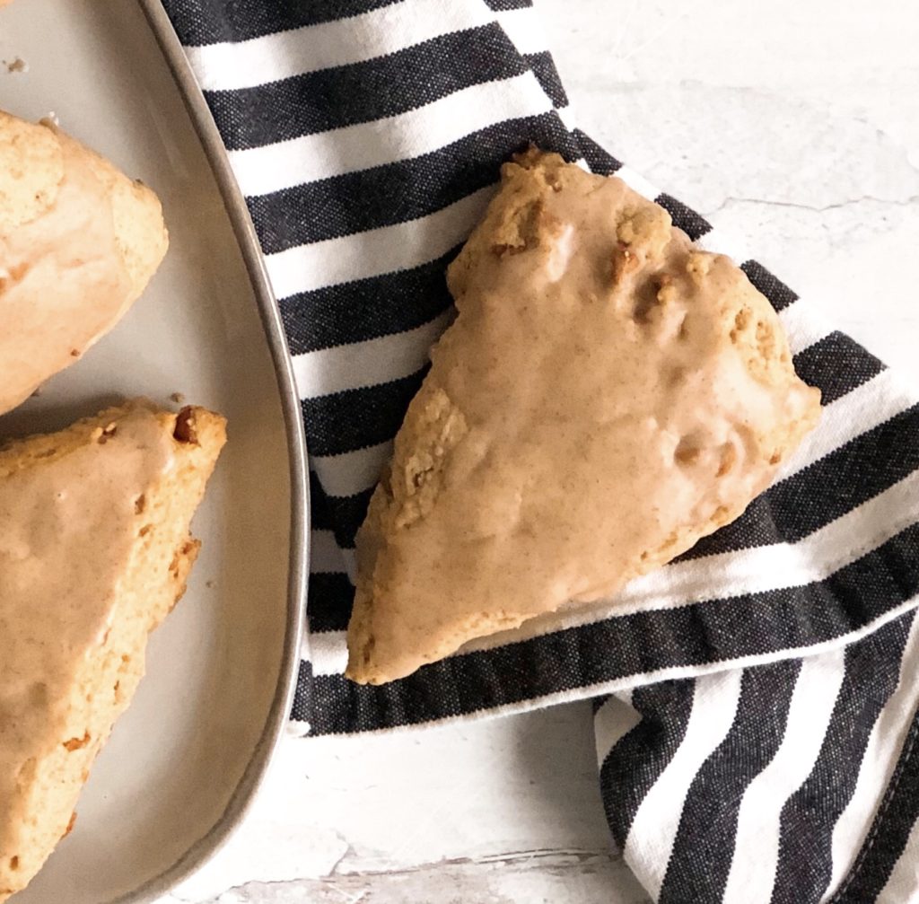 Cinnamon Chip Scone on a black and white stripe napkin sitting next to a plate of scones