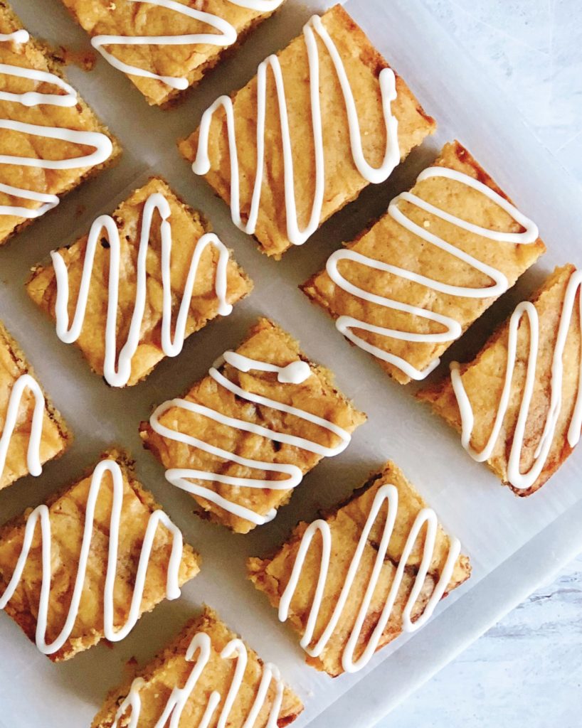 Pumpkin Snickerdoodle Bars with Icing Drizzle lined up on a marble board. 