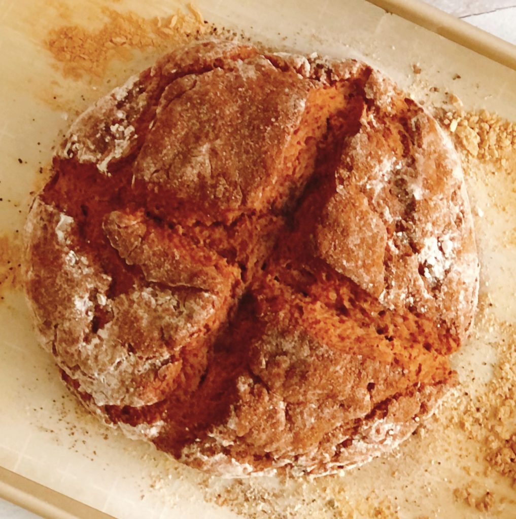 Pumpkin Spice Soda Bread dusted with flour on a piece of parchment.