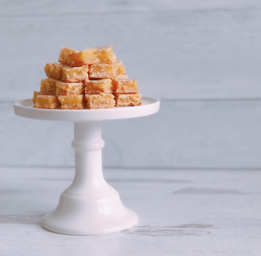 Limoncello Squares stacked on a white pedestal dish.