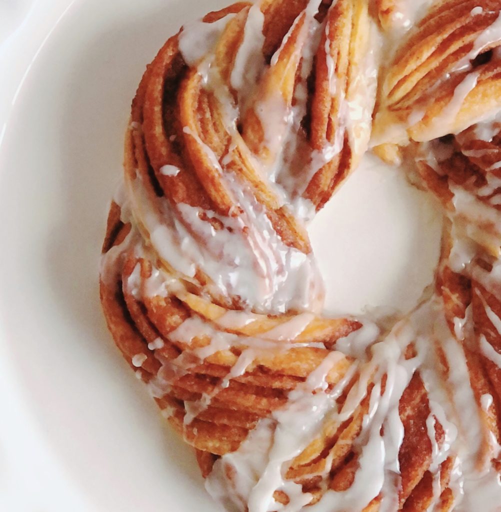 Cinnamon Roll Crescent Wreath with icing drizzled over top.