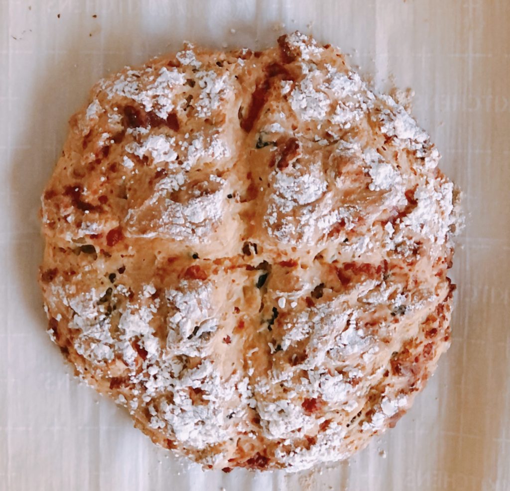 Mozzarella and Olive Soda Bread, not sliced and sprinkled with flour.