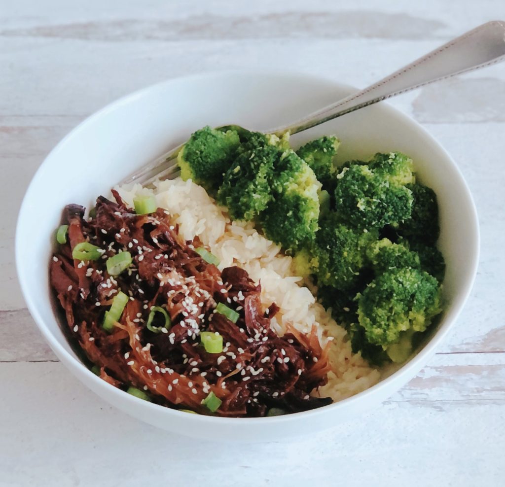 Slow Cooker Spicy Beef in a white bowl with rice and broccoli.