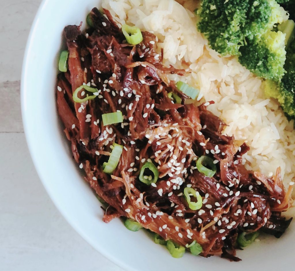 Slow Cooker Spicy Beef in a white bowl with rice and broccoli.
