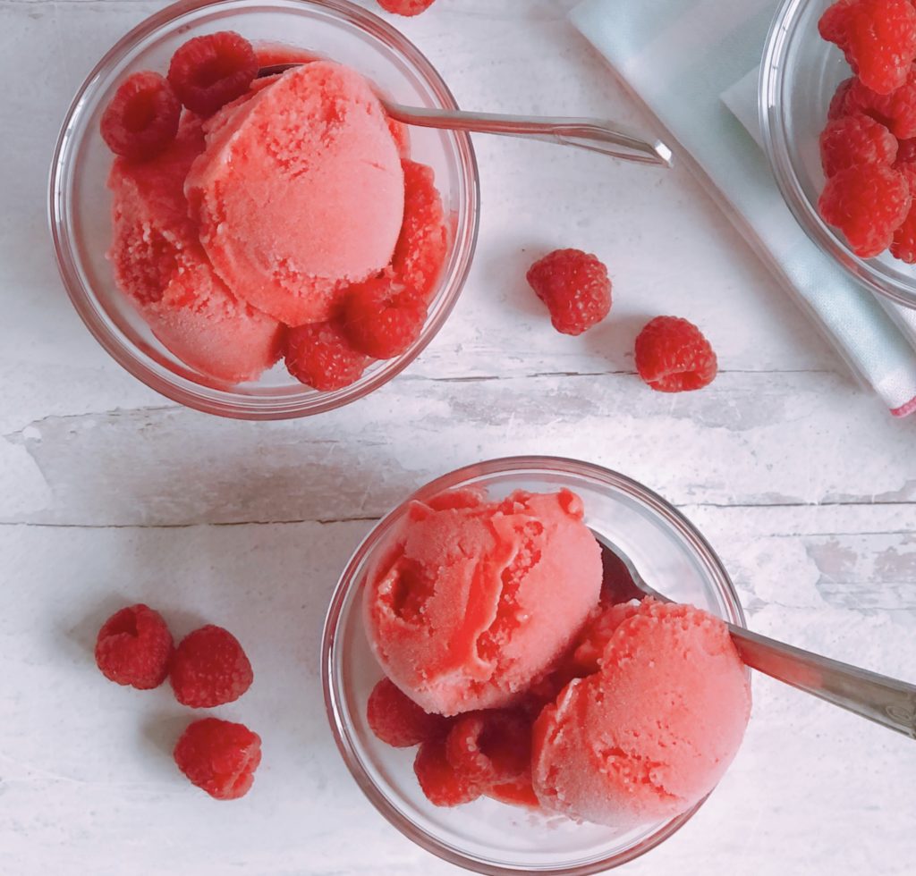 Raspberry Sorbet scooped into small glass bowls.