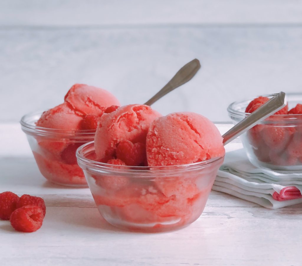 Raspberry Sorbet scooped into small glass bowls.