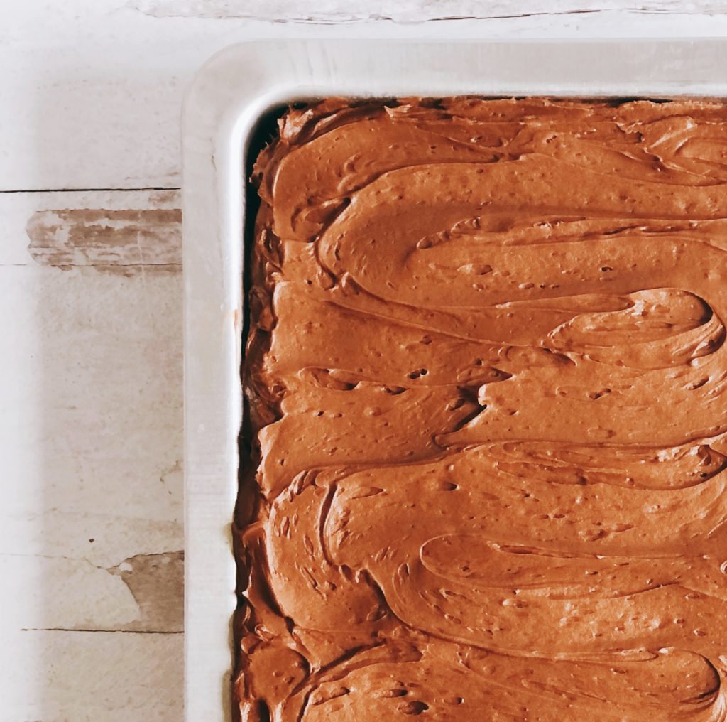 Dark Chocolate Sheet Cake in a cake pan with swirled frosting