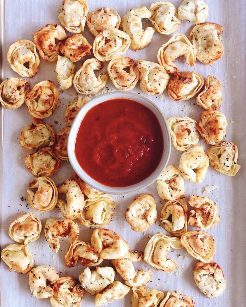 Air Fryer Tortellini on a sheet pan with tomato sauce for dipping