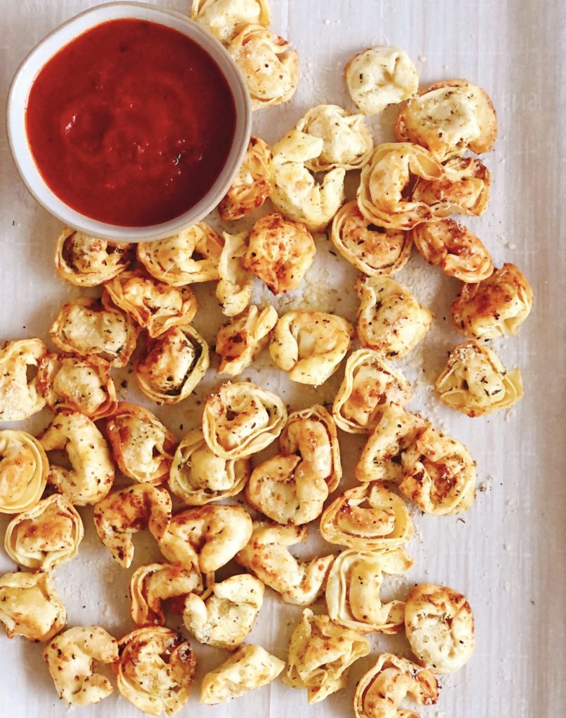 Air Fryer Tortellini on a sheet pan with tomato sauce for dipping