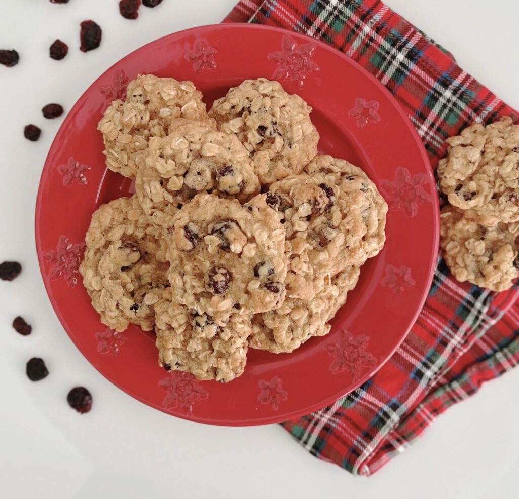 Cranberry Oatmeal Cookies on a red plate sitting on top of a plaid napkin