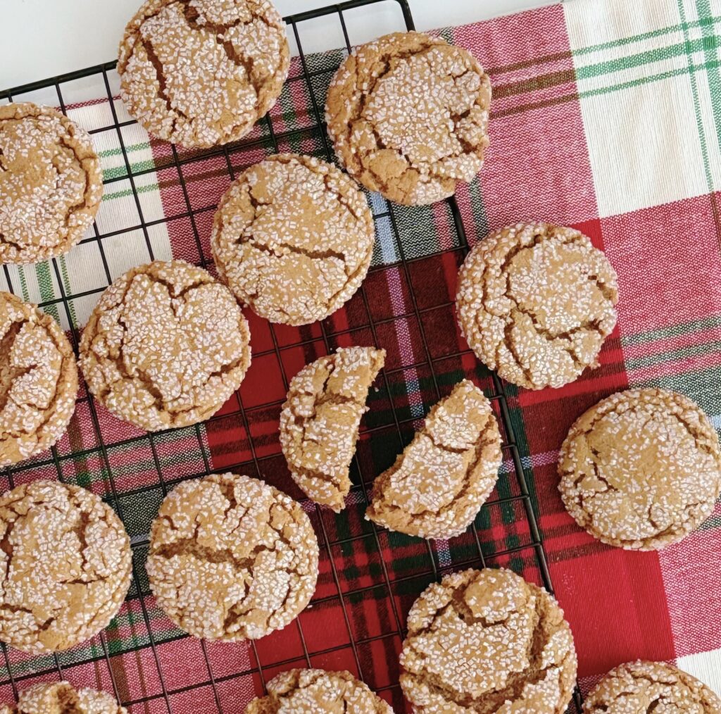 Ginger Crinkle Cookies on a wire rack on top of a plain tablecloth.