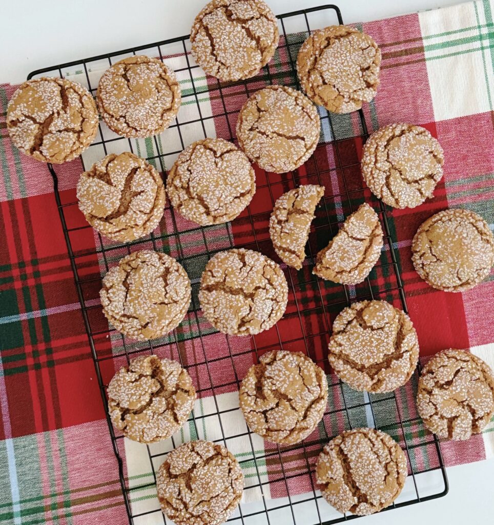 Ginger Crinkle Cookies on a wire rack on top of a plaid tablecloth.